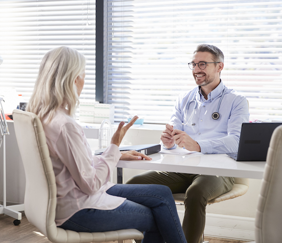 A woman is sitting down with a provider at Lee Plastic Surgery to learn more about hormone replacement therapy in Port St. Lucie.