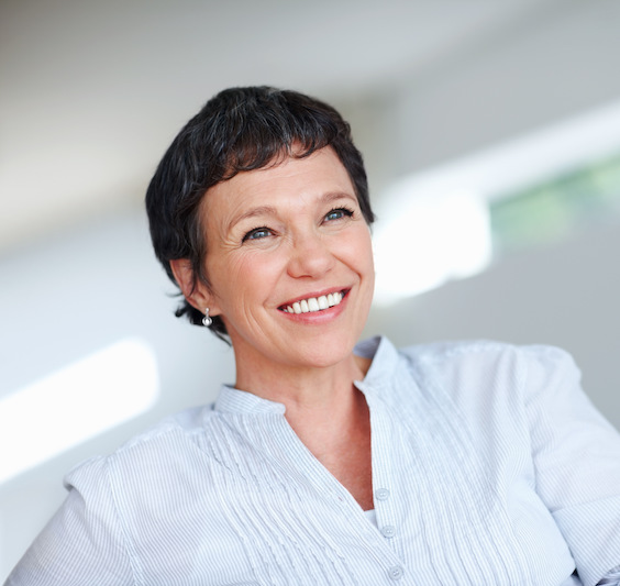 A middle aged woman smiles after reducing her age-related symptoms with hormone replacement therapy in Port St. Lucie.